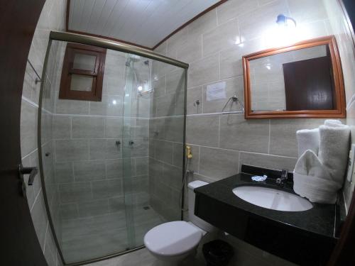 a bathroom with a shower and a sink and a toilet at Pousada Larissa in Paraty