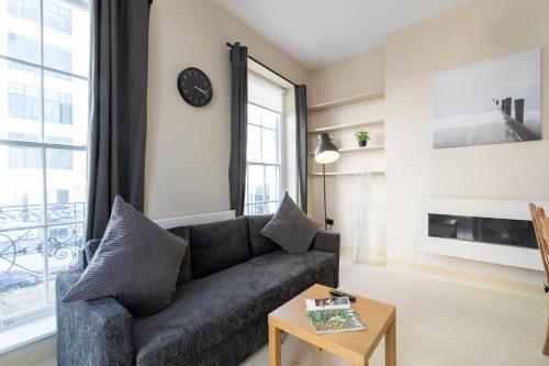a living room with a couch and a clock on the wall at Camden City Living in London