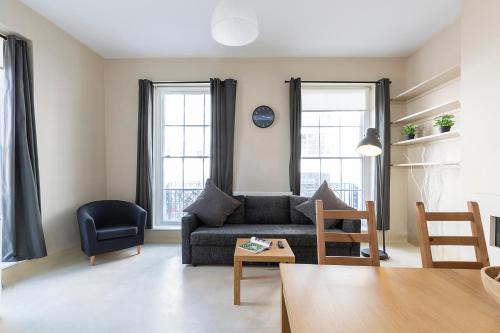 a living room with a couch and two windows at Camden City Living in London
