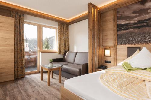 フィスにあるHotel Appartement Platzergasseのベッドとソファのあるホテルの部屋