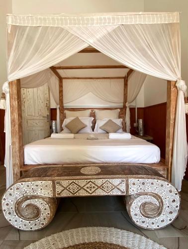a bedroom with a large bed with a canopy at Samura Maldives Guest House Thulusdhoo in Thulusdhoo