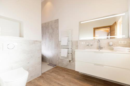 a white bathroom with a sink and a mirror at Appartement Pension Auhof in Going