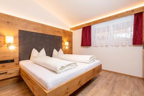 a bedroom with a large bed with white sheets at Appartement Pension Auhof in Going