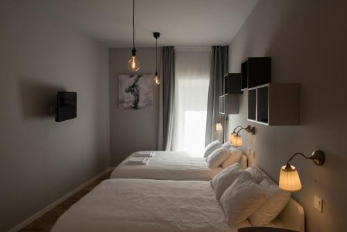 a hotel room with two beds and a window at S&L3 REPUBLIC ZAGREB CENTER in Zagreb