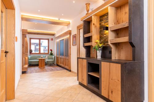 a hallway with a library with wooden shelves at Appartement Pension Auhof in Going