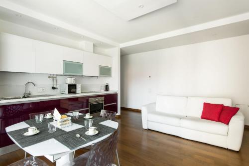 a kitchen and living room with a table and a couch at Roggia Apartments by Quokka 360 - a stone's throw from Ciani Park in Lugano