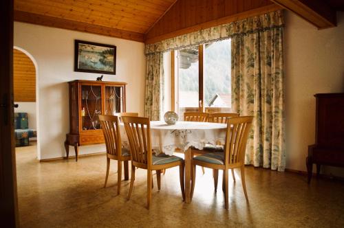 d'une salle à manger avec une table, des chaises et une fenêtre. dans l'établissement Haus Dorfer, à Döbriach