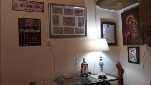 a room with a table with a lamp and posters on the wall at Chronis Family Villas in Krousón
