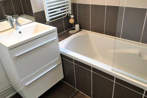 La salle de bains est pourvue d'un lavabo blanc et d'une baignoire. dans l'établissement LA CARAVELLE T3 au cœur de ville proche de la plage, à Le Touquet-Paris-Plage