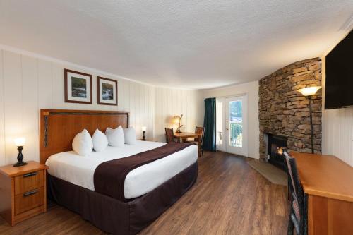 a hotel room with a large bed and a fireplace at River Terrace Resort & Convention Center in Gatlinburg