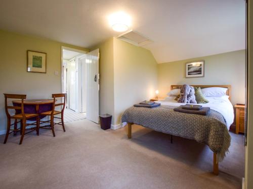 a bedroom with a bed and a table and chairs at Granary, Cheltenham in Cheltenham