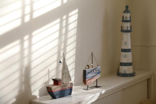 uma prateleira com um farol e bonecos de brinquedo. em The Boathouse for two, St Davids, Garage Parking em St. Davids