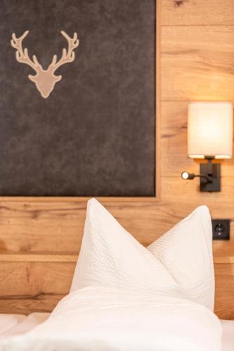 a bedroom with a bed with a picture of a deer on the wall at Appartement Pension Auhof in Going