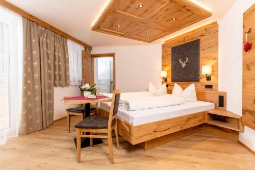 a hotel room with a bed and a table at Appartement Pension Auhof in Going