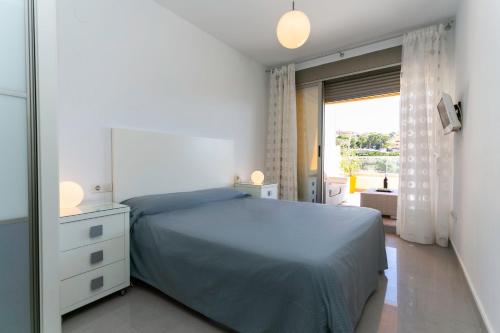 a bedroom with a bed and a large window at Big Terrace Apartment Cullera in Cullera