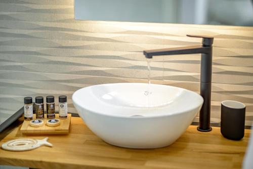 a bathroom with a white sink and a faucet at Thealos Santorini in Pirgos