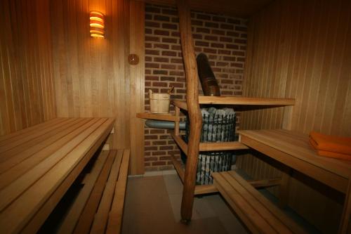 a sauna with wooden benches and a brick wall at Sodyba Pas Drambliuka in Svėdasai