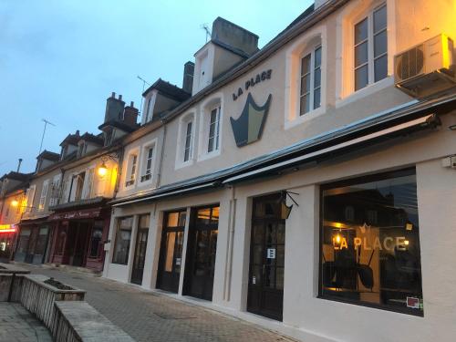 a building on a street with a store at Hotel restaurant LA PLACE in Saint-Amand-Montrond