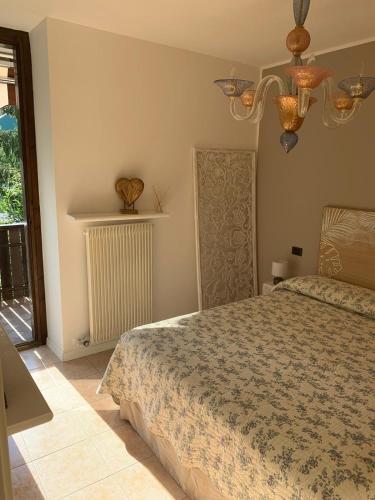 a bedroom with a bed and a window at Appartamento Levico lake in Levico Terme