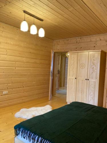 a bedroom with a bed in a room with wooden walls at Chata Nad Potokiem w Górach in Kamesznica