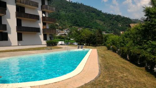 a swimming pool in front of a building at Appartamento Levico lake in Levico Terme