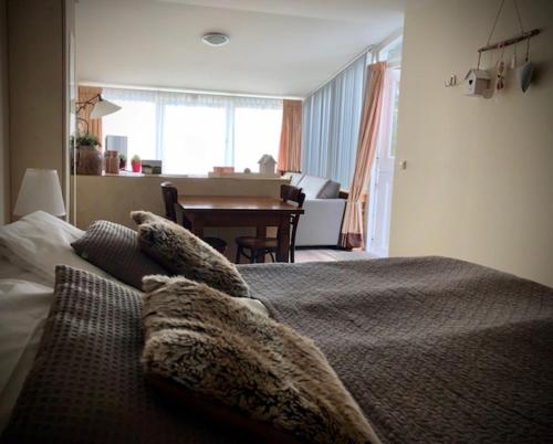 a bedroom with a bed with pillows and a living room at Herberg Oud Holset in Lemiers