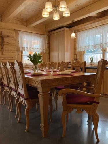 uma sala de jantar com uma grande mesa de madeira e cadeiras em Chata Nad Potokiem w Górach em Kamesznica