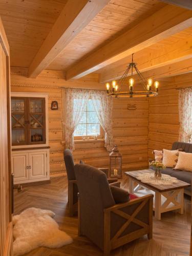 a living room in a log cabin with a chandelier at Chata Nad Potokiem w Górach in Kamesznica