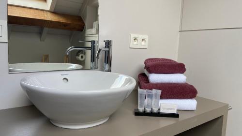 a bathroom with a bowl sink and towels on a counter at Hotel - B&B PassaDia in Zwevegem