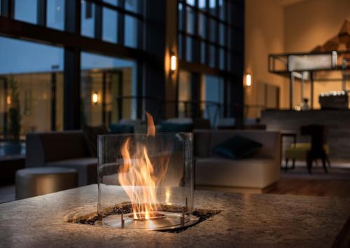 a fire in a glass container on a table at Holiday Inn Resort Shinano-Omachi Kuroyon by IHG in Omachi
