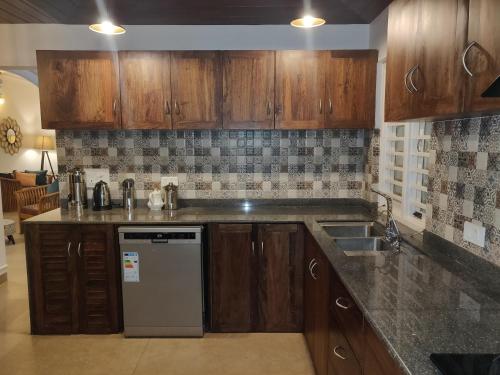 a kitchen with wooden cabinets and a counter top at Elegant holiday homes Coorg in Madikeri