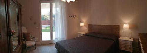 a bedroom with a bed and a large window at Bilocale Papavero, Magnolia o Girasole in San Felice del Benaco