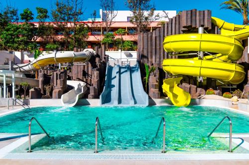 a pool with a water slide in a resort at Spring Hotel Bitácora in Playa de las Americas