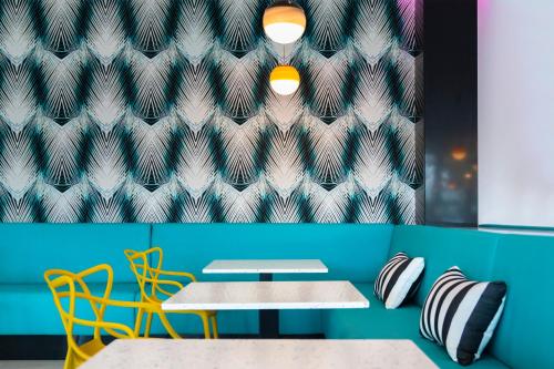 a room with two tables and chairs and a blue wall at Spring Hotel Bitácora in Playa de las Americas