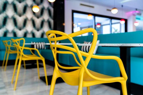 two yellow chairs sitting at a table in a restaurant at Spring Hotel Bitácora in Playa de las Americas