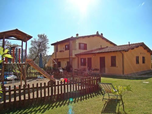 dom z placem zabaw przed ogrodzeniem w obiekcie Agriturismo La Svolta w mieście Manciano