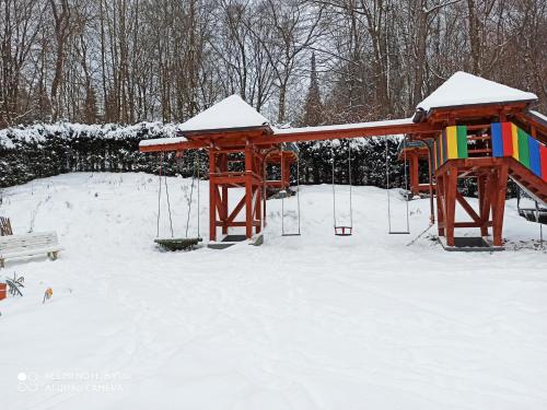 a playground in the snow with a swing at Pension Waldsauna in Arnsberg