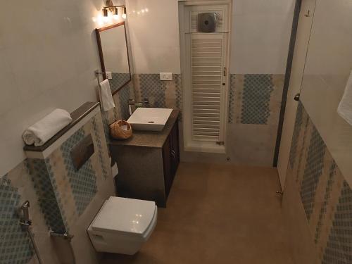 La salle de bains est pourvue de toilettes et d'un lavabo. dans l'établissement Elegant holiday homes Coorg, à Madikeri