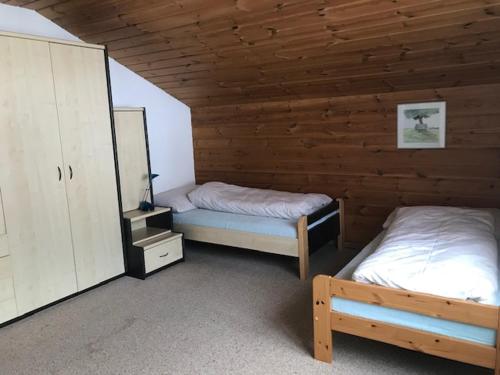 a room with two beds in a wooden cabin at Hotel Alpina in Unterwasser