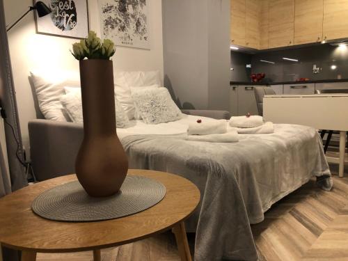 pokój z łóżkiem i wazą na stole w obiekcie Apartment Katowice Center w mieście Katowice