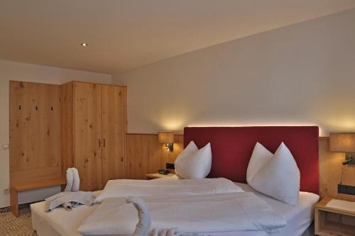 a bedroom with a large bed with a red headboard at Appartement Schörghofer in Filzmoos