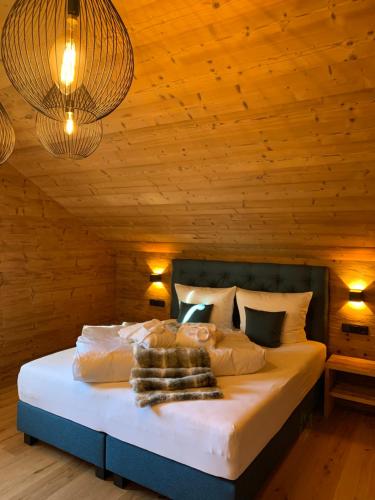 a bedroom with a bed with wooden walls and lights at Chalet RelaxAlp Garfrescha in Sankt Gallenkirch