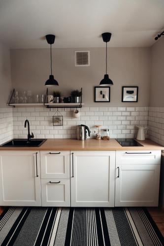 a kitchen with white cabinets and a sink at Teatra street apartment in Balvi