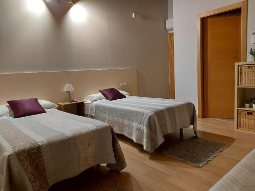 a bedroom with two beds with purple pillows at Ultreia in Portomarin
