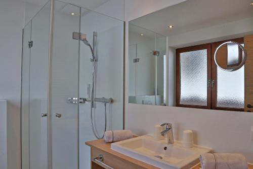 a bathroom with a sink and a shower with a mirror at Appartement Schörghofer in Filzmoos