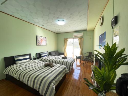 two beds in a room with green walls at NAGO Sakura Resort Inn - Vacation STAY 14445v in Nago