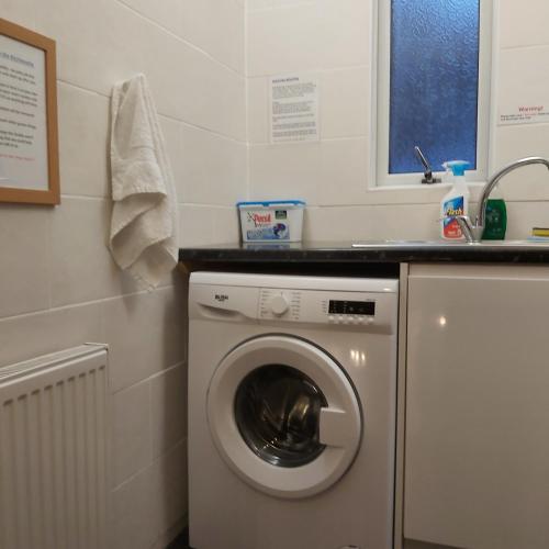 a laundry room with a washing machine and a sink at St Albans Guest House, Dover in Dover