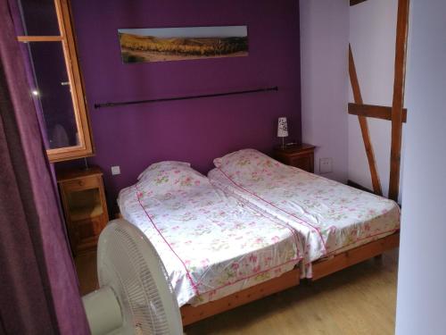 テュルクアイムにあるla grange de louisの紫の壁の小さなベッド1台