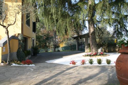 a large vase in front of a building with flowers at La Stregatta in Fucecchio