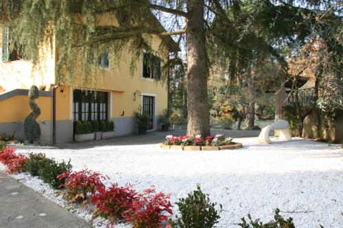 a park with a tree and flowers in front of a building at La Stregatta in Fucecchio